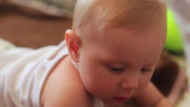 Newborn baby girl crawling on the carpet on the floor with toys — Stock Video