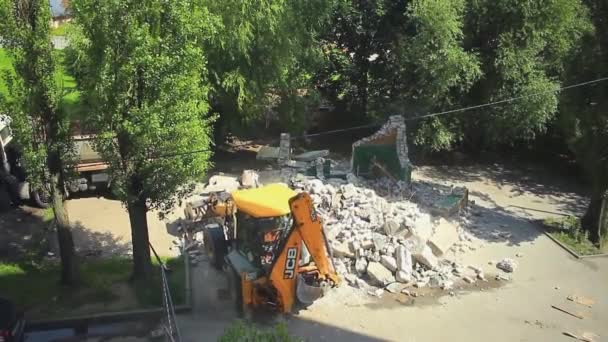 Rusland Kaliningrad 2019 gele graafmachine breekt een bakstenen gebouw in de werf van een woongebouw — Stockvideo