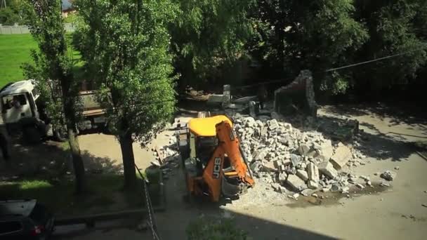 Rusland Kaliningrad 2019 gele graafmachine breekt een bakstenen gebouw in de werf van een woongebouw — Stockvideo