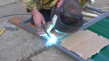 Kaynak makinesiyle çalışan bir adamın elleri.