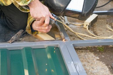 Metal kaynakçılığı yapan adamların elleri