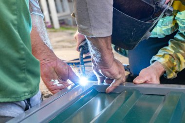 Metal kaynakçılığı yapan adamların elleri