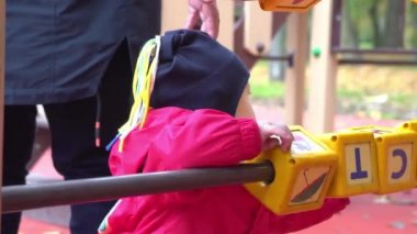 Küçük kız oyun bahçesinde küplerle oynuyor.