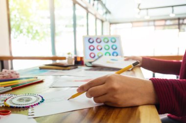 Atelier terzi aracı ve renk grafikleri, meslek ve iş işgal, moda tasarımcısı şık konsept çizimler giyim için çizim işyerinde kadın moda tasarımcısı kapatın.