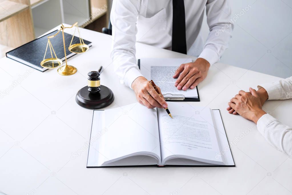 Businesspeople or lawyer having team meeting discussing agreement contract documents, judge gavel with Justice lawyers at law firm in background, Legal law, advice and justice concept.