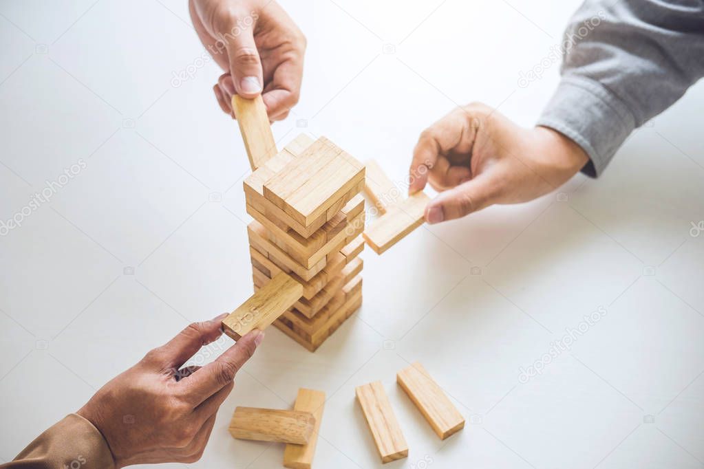 Alternative risk plan and strategy in business, Young intelligent business team playing the wood game, hands of executive cooperation placing wood block on the tower, Collaborative management.