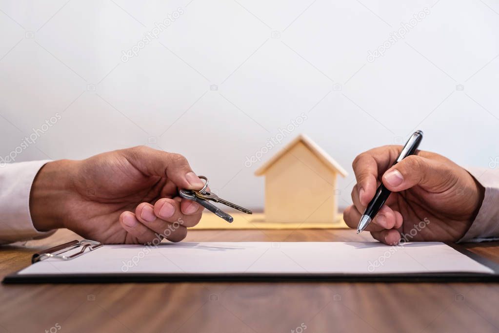 Man signing contract of loan agreement document with bank broker agent insurance, Real Estate concept.