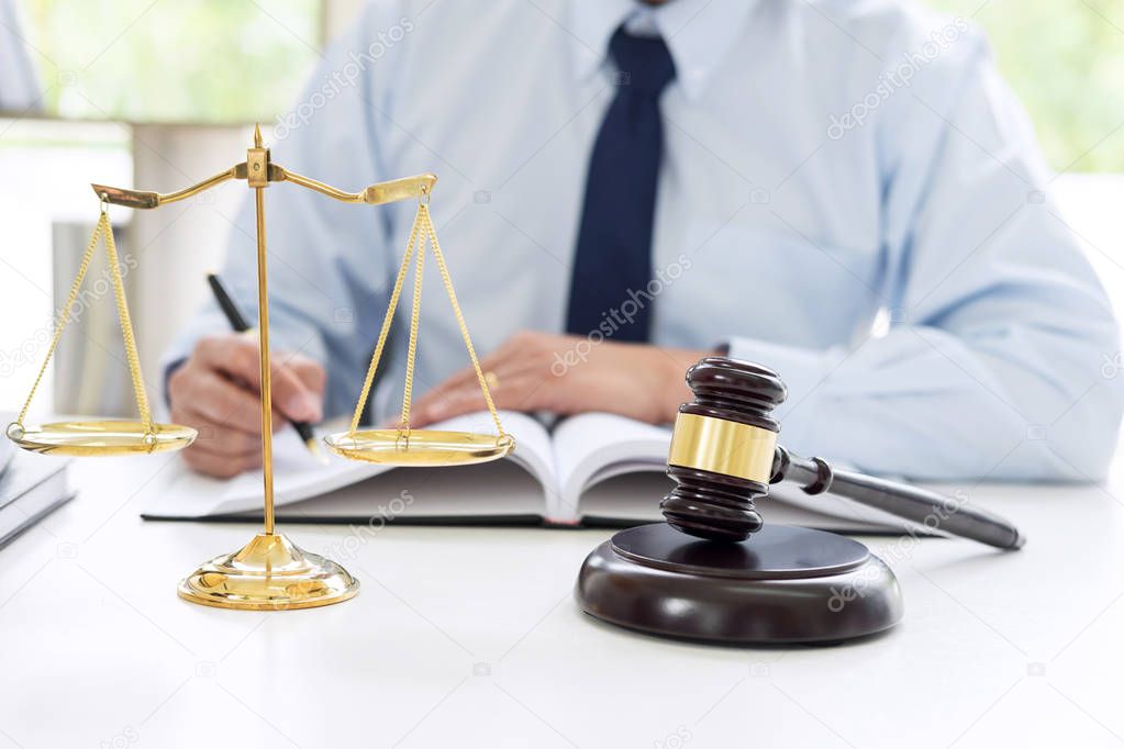 Judge gavel with scales of justice, male lawyers working having at law firm in office. Concepts of law.