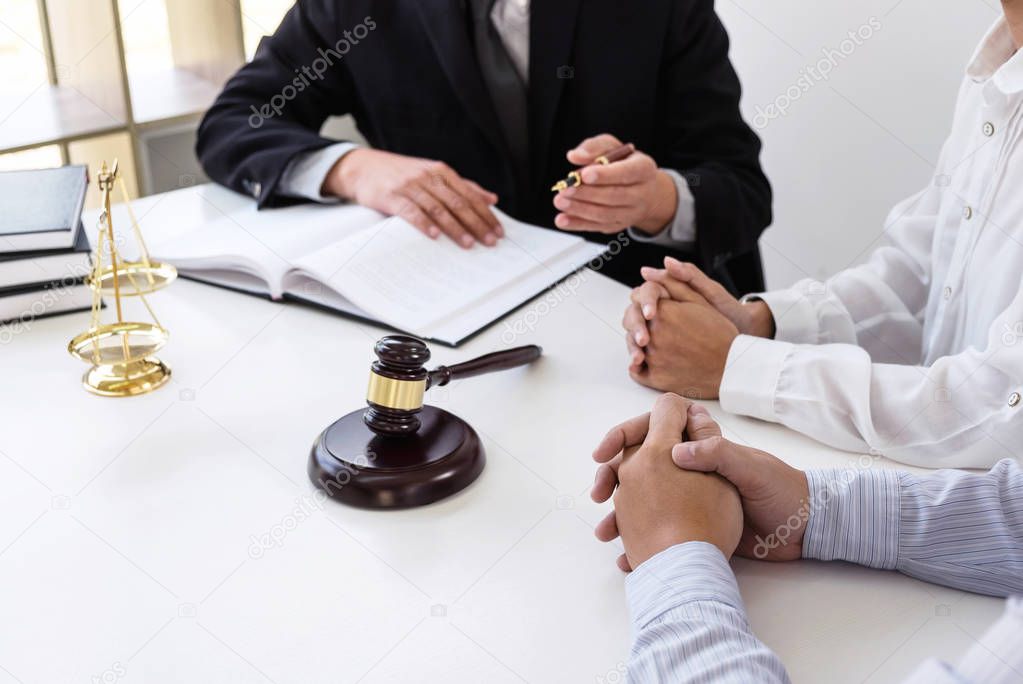 Close up of gavel, Male lawyer or judge Consult with client and working with Law books, report the case on table in modern office, Law and justice concept.