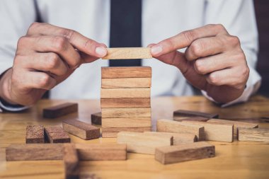 İş büyüme kavramı ile ahşap blok yapmak için riske, adamın elini kadar kazık vardır ve bir ahşap blok istifleme, alternatif risk kavramı, plan ve strateji otelde iş.