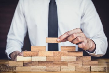 İş büyüme kavramı ile ahşap blok yapmak için riske, adamın elini kadar kazık vardır ve bir ahşap blok istifleme, alternatif risk kavramı, plan ve strateji otelde iş.
