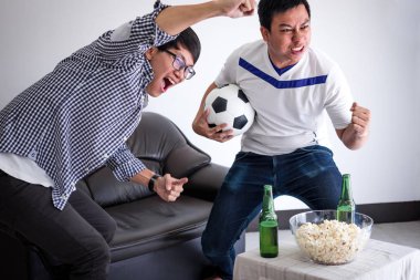 Tv ve içki bira ile kutluyor tezahürat futbol takımı maç ve evde, patlamış mısır yemek futbol izlerken genç mutlu Asya erkekler aile veya futbol hayranları spor ve eğlence kavramının.