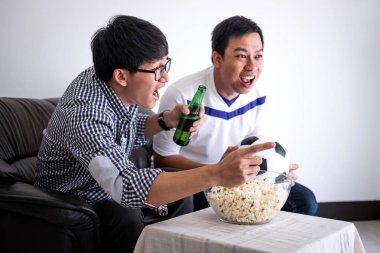 Tv ve içki bira ile kutluyor tezahürat futbol takımı maç ve evde, patlamış mısır yemek futbol izlerken genç mutlu Asya erkekler aile veya futbol hayranları spor ve eğlence kavramının.