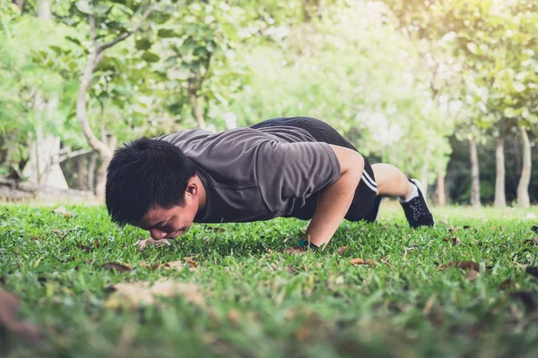 Dışarıda yaz Park çimenlerin üzerinde işin adam push-up egzersiz egzersiz fitness.