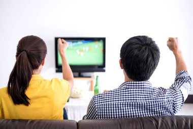 Genç Asyalı Çift tv ve bira ve patlamış mısır vasıl ev ile kutluyor tezahürat futbol takımı, spor ve eğlence kavramının maç futbol izlemeye bayılıyorum.