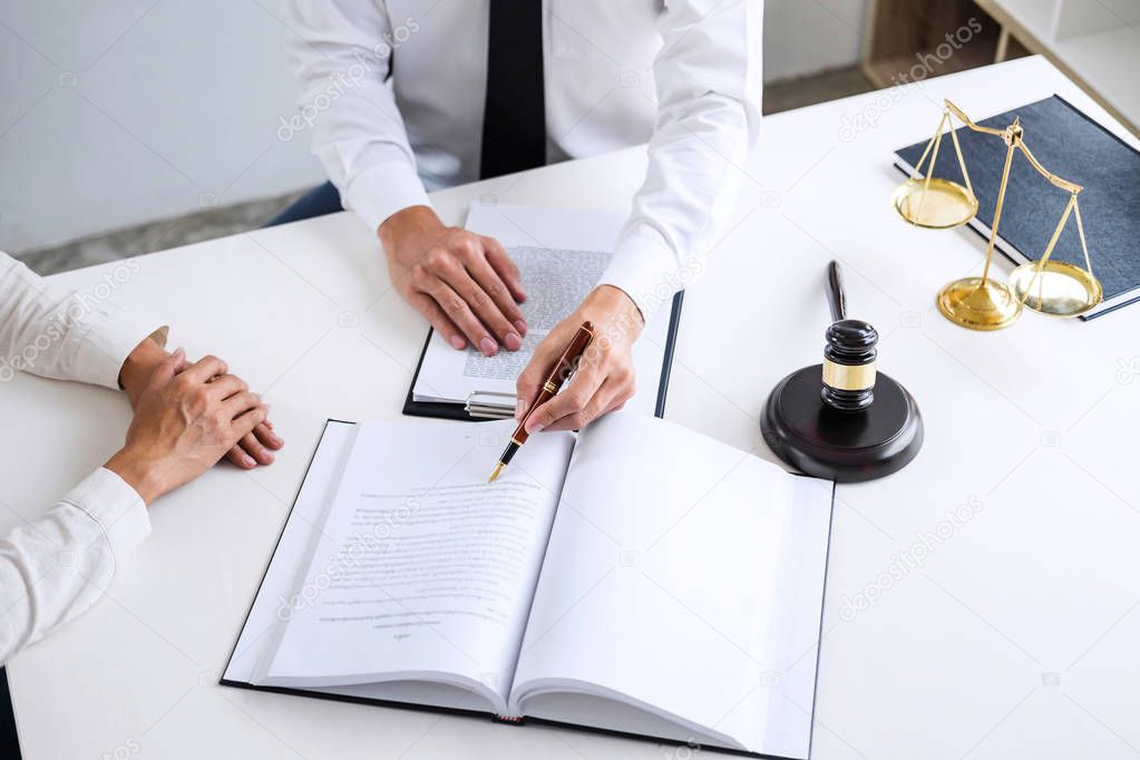 Businesspeople or lawyer having team meeting discussing agreement contract documents, judge gavel with Justice lawyers at law firm in background, Legal law, advice and justice concept.