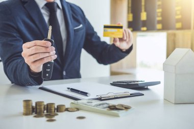 Anahtar, bir kredi kartı tutan ve yeni araba ve ev kredisi, ulaşım ve mülkiyet kavramı satış fiyat hesaplama satıcısı.