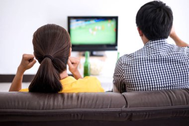 Genç Asyalı Çift tv ve bira ve patlamış mısır vasıl ev ile kutluyor tezahürat futbol takımı, spor ve eğlence kavramının maç futbol izlemeye bayılıyorum.