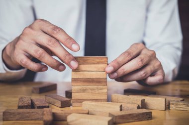 İş büyüme kavramı ile ahşap blok yapmak için riske, adamın elini kadar kazık vardır ve bir ahşap blok istifleme, alternatif risk kavramı, plan ve strateji otelde iş.