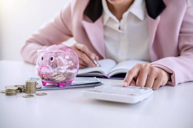 Rapor yazma ve hesap makinesi analizi iş yatırım stratejisi için para sikke ve Doları, mali kavramı gelir ile kullanarak kumbara para koyarak iş kadını.