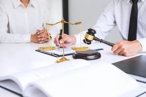 Businesspeople or lawyer having team meeting discussing agreement contract documents, judge gavel with Justice lawyers at law firm in background, Legal law, advice and justice concept.