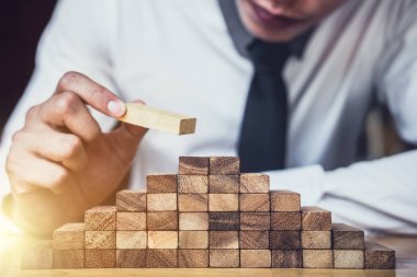 İş büyüme kavramı ile ahşap blok yapmak için riske, adamın elini kadar kazık vardır ve bir ahşap blok istifleme, alternatif risk kavramı, plan ve strateji otelde iş.