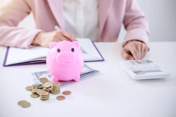 Business Woman Putting Coins Piggy Bank Writing Report Using Calculator — Stock Photo, Image