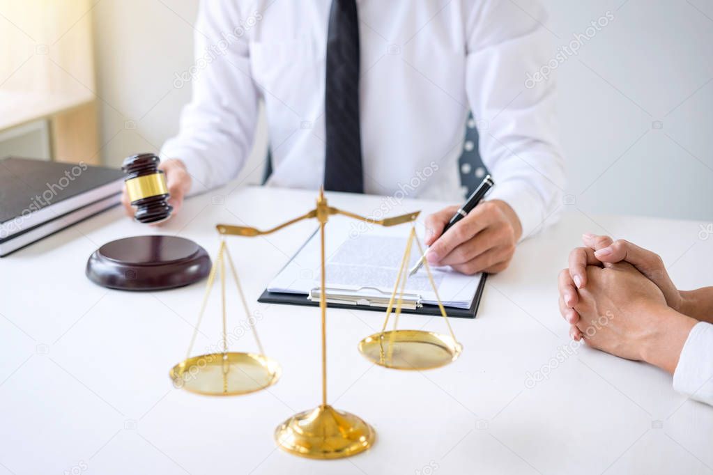 Businesspeople or lawyer having team meeting discussing agreement contract documents, judge gavel with Justice lawyers at law firm in background, Legal law, advice and justice concept.