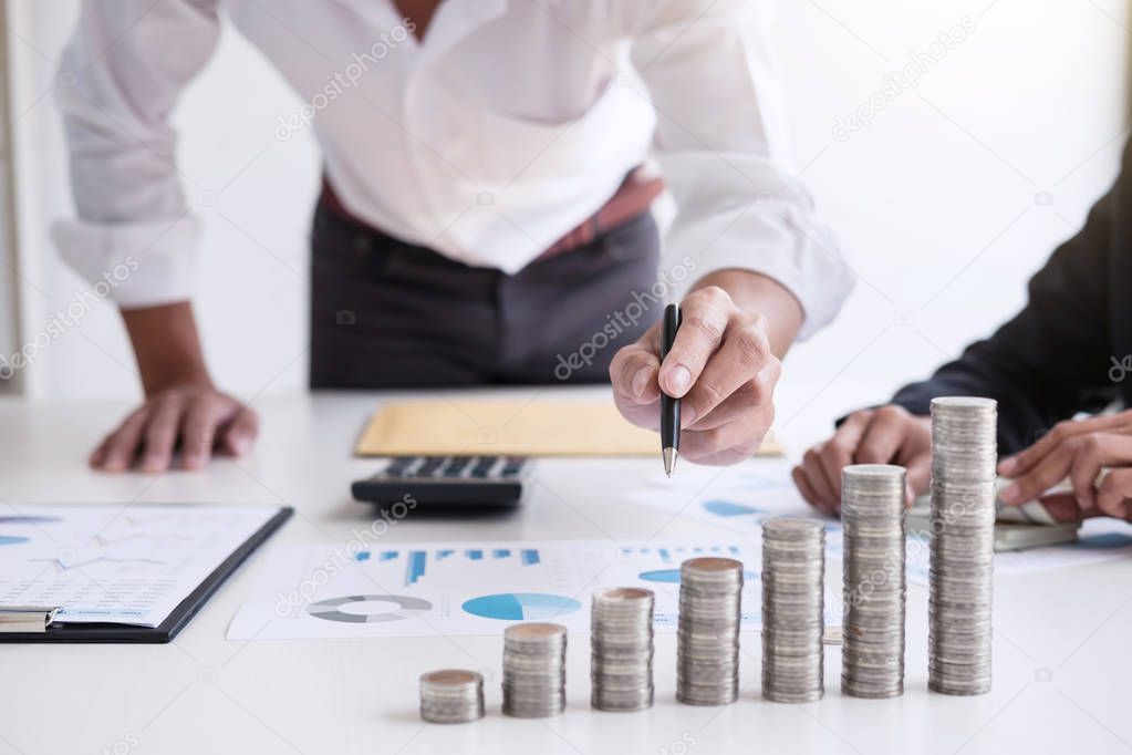 Business accountant or banker, Two business partner analysis with stock financial indices and growth stacking coin and financial costs wisely and carefully, investment and saving concept.
