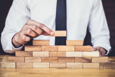 İş büyüme kavramı ile ahşap blok yapmak için riske, adamın elini kadar kazık vardır ve bir ahşap blok istifleme, alternatif risk kavramı, plan ve strateji otelde iş.