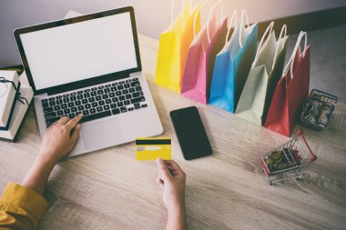 Genç kadın online web sitesi alışveriş ve kart ödeme kredi kartı, Online ödemeyi içeren ve konsept alışveriş dizüstü bilgisayar yazmaya.