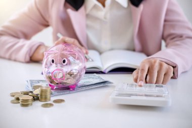 Rapor yazma ve hesap makinesi analizi iş yatırım stratejisi için para sikke ve Doları, mali kavramı gelir ile kullanarak kumbara para koyarak iş kadını.