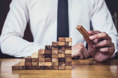 İş büyüme kavramı ile ahşap blok yapmak için riske, adamın elini kadar kazık vardır ve bir ahşap blok istifleme, alternatif risk kavramı, plan ve strateji otelde iş.