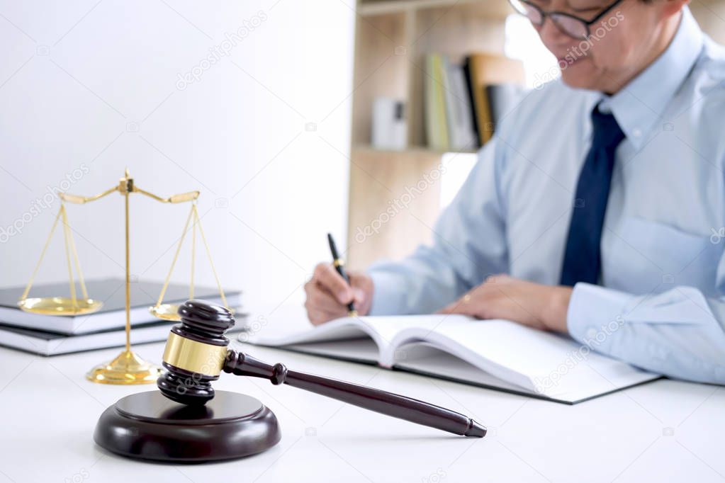 Judge gavel with scales of justice, male lawyers working having at law firm in office. Concepts of law.