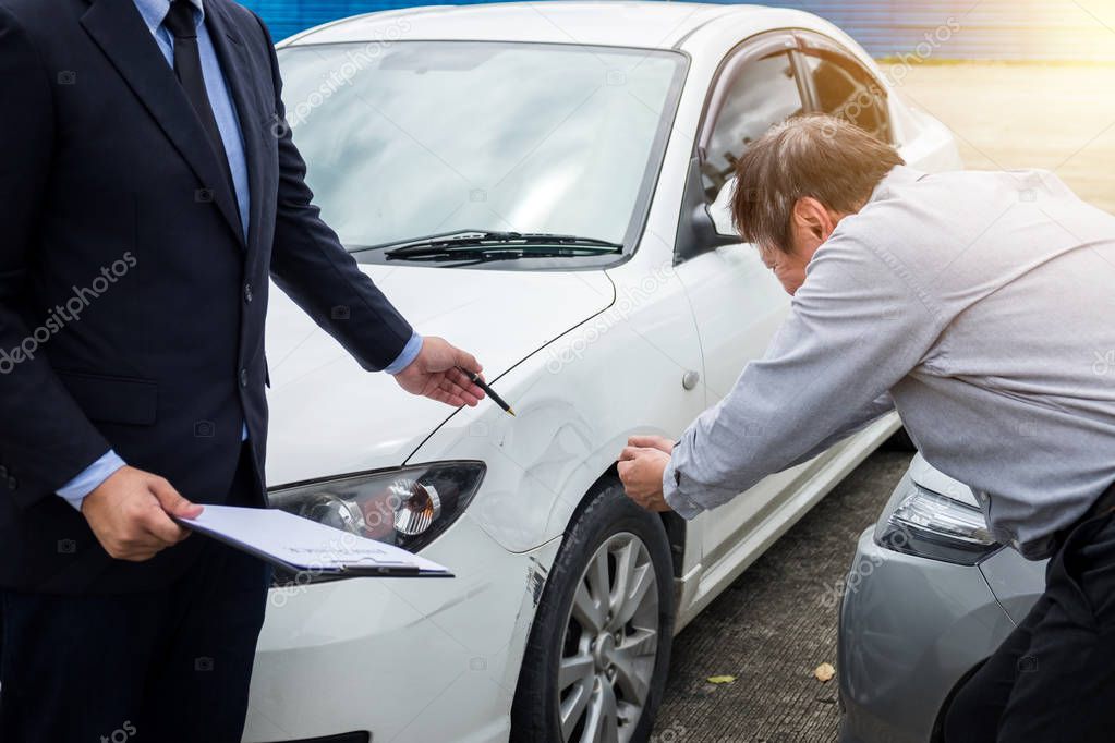 Insurance Agent examine Damaged Car and filing Report Claim Form after accident, Traffic Accident and insurance concept.