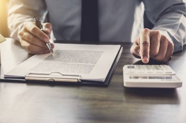 İş adamı ya da avukat muhasebeci, hesap makinesi analizi kullanarak mali yatırım yapıyor. Mali belge raporu, emlak ve ev kredisi sigortası..