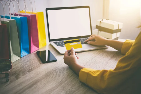 Genç kadın online web sitesi alışveriş ve kart ödeme kredi kartı, Online ödemeyi içeren ve konsept alışveriş dizüstü bilgisayar yazmaya.