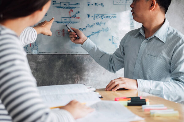 High school or college student group catching up workbook and learning tutoring in classroom and reading, doing homework and lesson practice preparing exam to entrance, education concept.