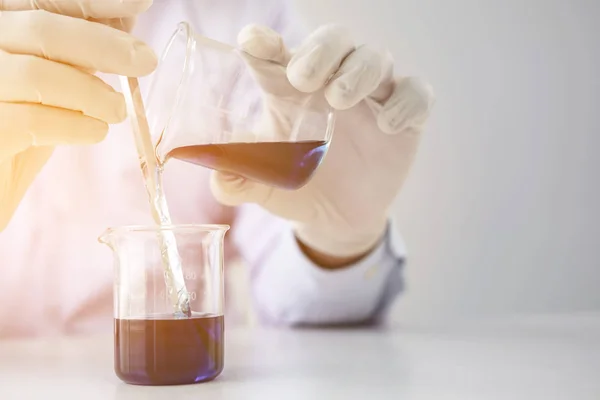 科学者や医療白衣の臨床検査室でガラスのフラスコで試薬を混合との研究のバイオ テクノロジーの実験装置での作業に — ストック写真