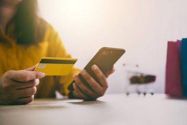 Online alışveriş web sitesi ve ödeme kredi kartı, Online ödeme ve alışveriş kavramı için akıllı telefon kullanan genç kadın görüntüsünü.