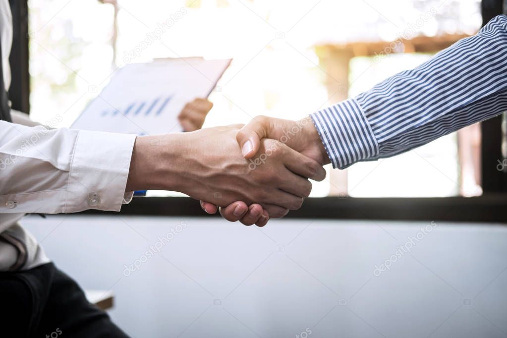Finishing up a meeting, Two Business handshake of collaboration after discussing good deal of Trading contract for both companies.