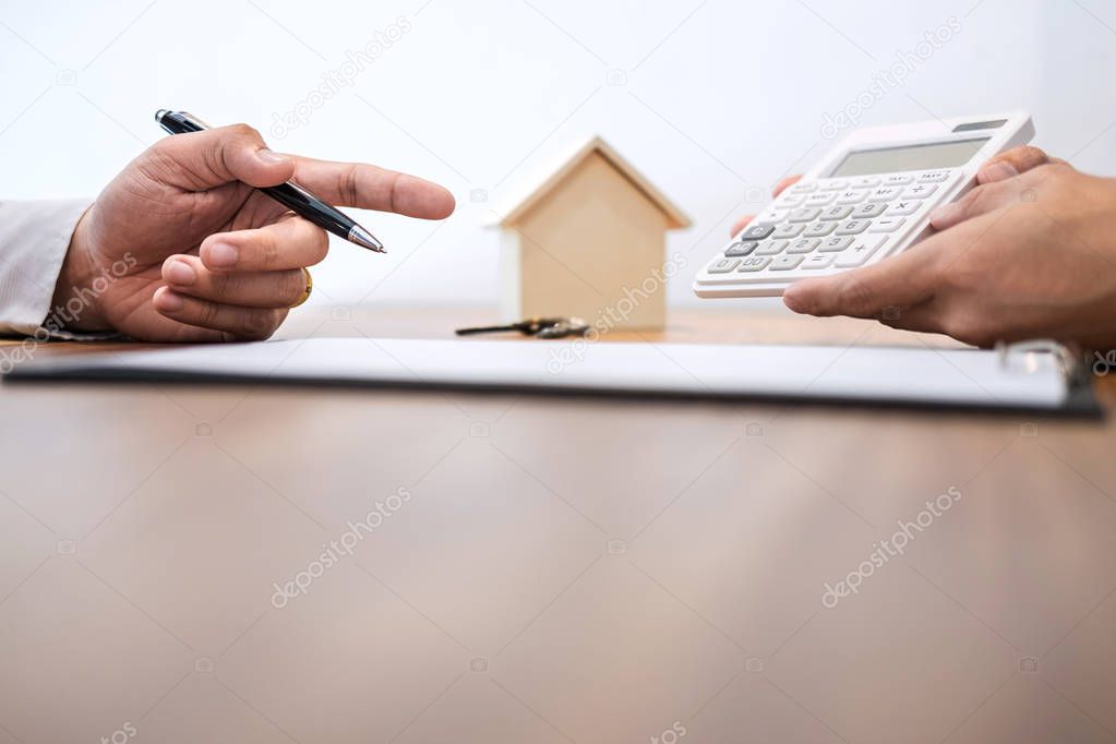 Man sign a home insurance policy on home loans, Agent agent holds loan investment chart graph documents and calculating table installment payment, Real Estate concept.