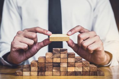 İş büyüme kavramı ile ahşap blok yapmak için riske, adamın elini kadar kazık vardır ve bir ahşap blok istifleme, alternatif risk kavramı, plan ve strateji otelde iş.