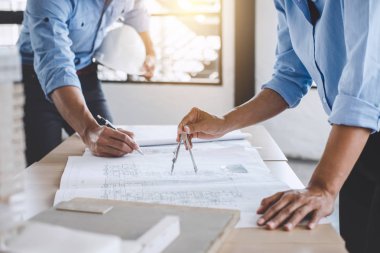 Mimar veya bina ve araçlar çalışma sitesi, inşaat kavramı içinde mühendislik modeli ortak çalışma projesi için Toplantı planı üzerinde çalışan mühendis.