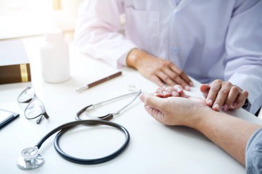 Doktor alarak ve muayene sırasında hastanın bilek ağrı kontrol beyaz ceket.