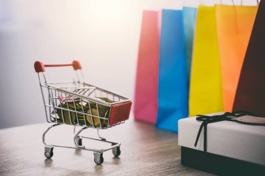 Ahşap zemin ve hediye kutusu ve alışveriş çantası, Online ödeme ve alışveriş kavramı üzerinde alışveriş sepeti modeli.