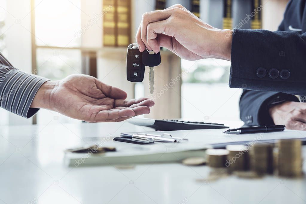 Salesman send key to customer after good deal agreement, successful car loan contract buying or selling new vehicle.