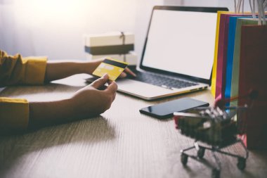 Genç kadın online web sitesi alışveriş ve kart ödeme kredi kartı, Online ödemeyi içeren ve konsept alışveriş dizüstü bilgisayar yazmaya.