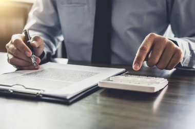 İş adamı ya da avukat muhasebeci, hesap makinesi analizi kullanarak mali yatırım yapıyor. Mali belge raporu, emlak ve ev kredisi sigortası..