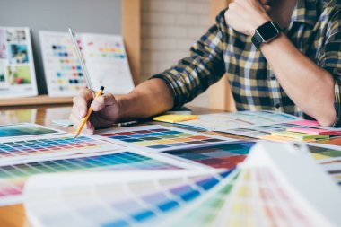 Genç yaratıcı grafik tasarımcı renk renk örneği örnekleri grafik iş araçları ve aksesuarları işyerinde boyama seçimi için seçmek için grafik tablet kullanma.